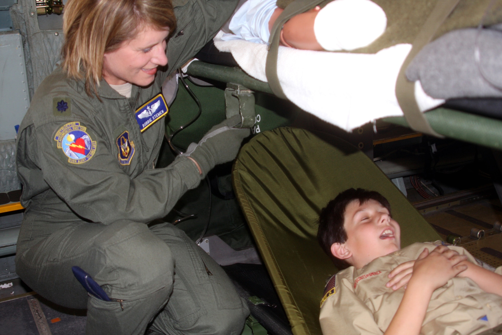 WRIGHT-PATTERSON AIR FORCE BASE, Ohio – Lt. Col. Bobbie Stemen, 445th Aeromedical Evacuation Squadron, is checking up on Boy Scout Michael Potvin, who is pretending to be a patient. More than 400 Boy and Girl Scouts from Ohio, Kentucky and Michigan, attended the 445th Airlift Wing’s first Scout Day May 15. (U.S.  Air Force photo/Senior Airman Mikhail Berlin)