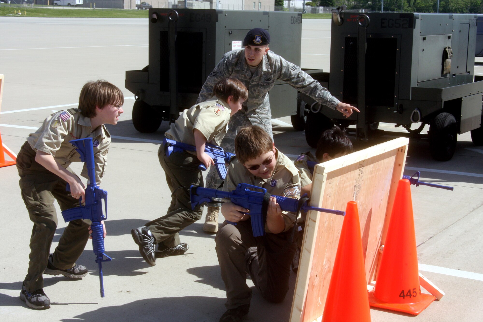 WRIGHT-PATTERSON AIR FORCE BASE, Ohio – Senior Airman Brian Horn, 445th Security Forces Squadron, helps three Boy Scouts reenact a scenario he gave so they can understand some of the highlights of his job as a security forces member. More than 400 Boy and Girl Scouts from Ohio, Kentucky and Michigan, attended the 445th Airlift Wing’s first Scout Day May 15. (U.S.  Air Force photo/Senior Airman Mikhail Berlin)