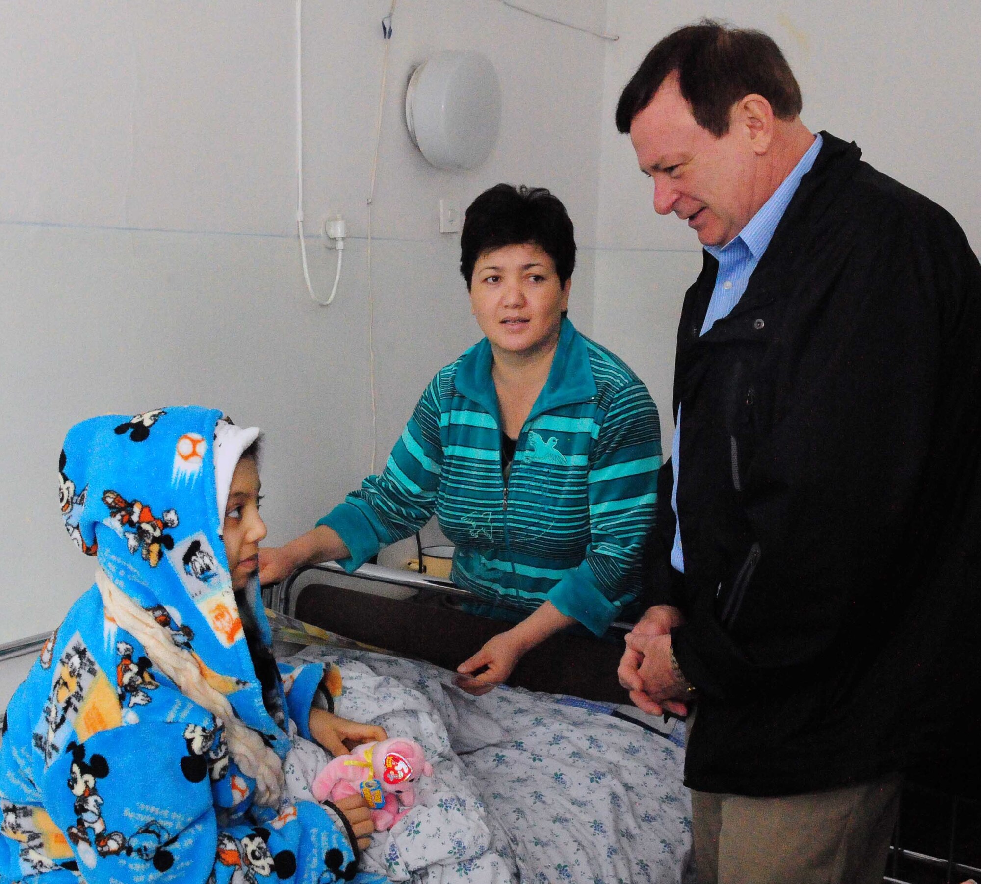 Ch. (Lt. Col.) James Kinsey, 376th Air Expeditionary Wing head chaplain, speaks to Firuza Nurahunova, a 13-year-old Kyrgyz girl, pictured here March 21, 2010, with her mother, Shakura, and Ch. (Lt. Col.) James Kinsey, was the 150th child to receive life-saving surgery funded by Airmen at the Transit Center at Manas, Kyrgyzstan. A recent “300 Lives in 30 Days” fundraiser at the Transit Center raised another $50,000 for the children’s heart surgery fund – enough to fund almost 90 more surgeries for children. (U.S. Air Force photo/Staff Sgt. Carolyn Viss)