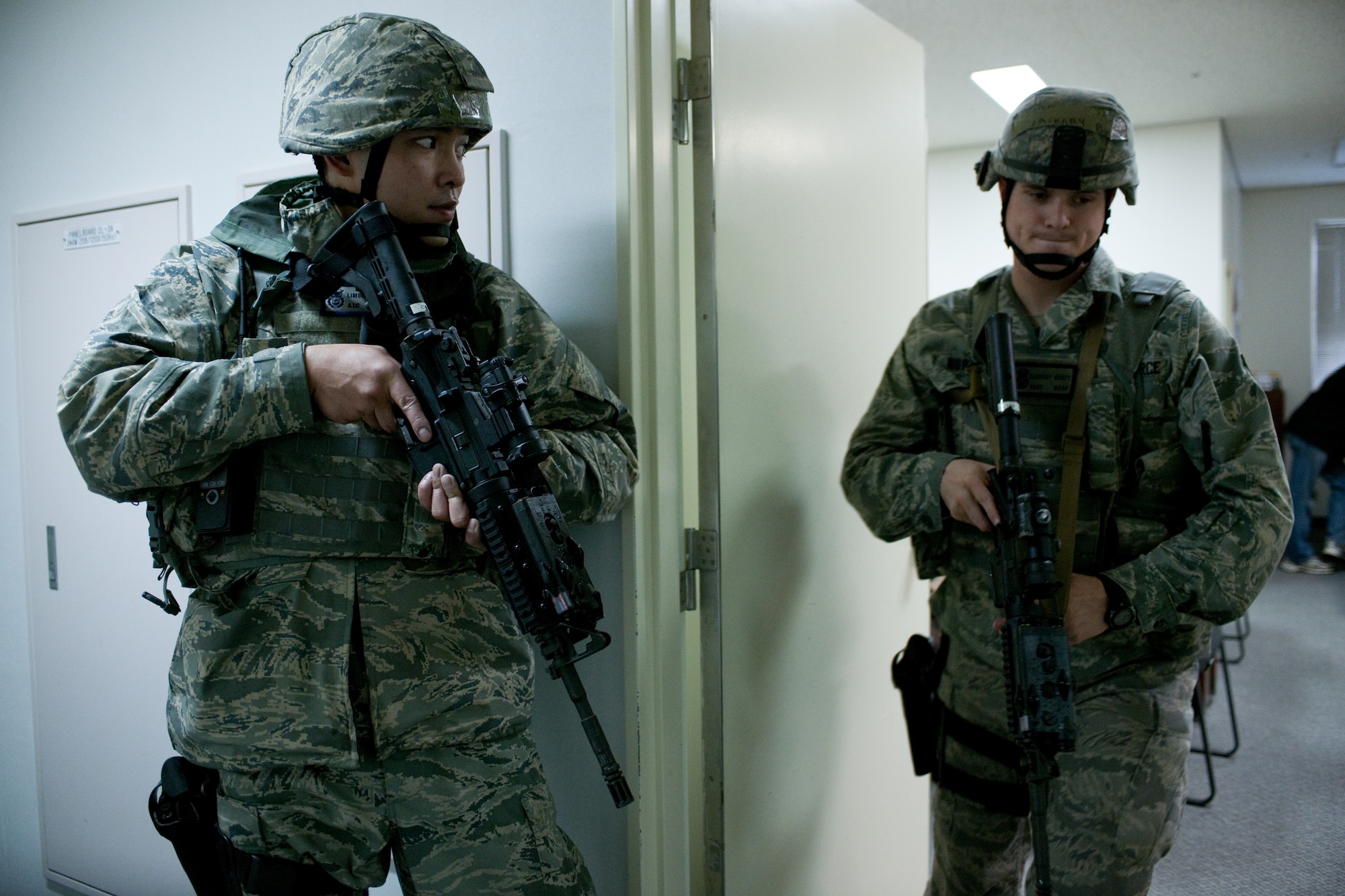 YOKOTA AIR BASE, Japan -- Airman 1st Class Limuel Beltran (right) guards a door while staff Sgt Zachary Burtt, both from the 374th Security Forces Squadron, surveys a robbery building here May 24 during an operational readiness exercise. Yokota is conducting an exercise through May 27 to maintain operational readiness. (U.S. Air Force photo/Osakabe Yasuo)