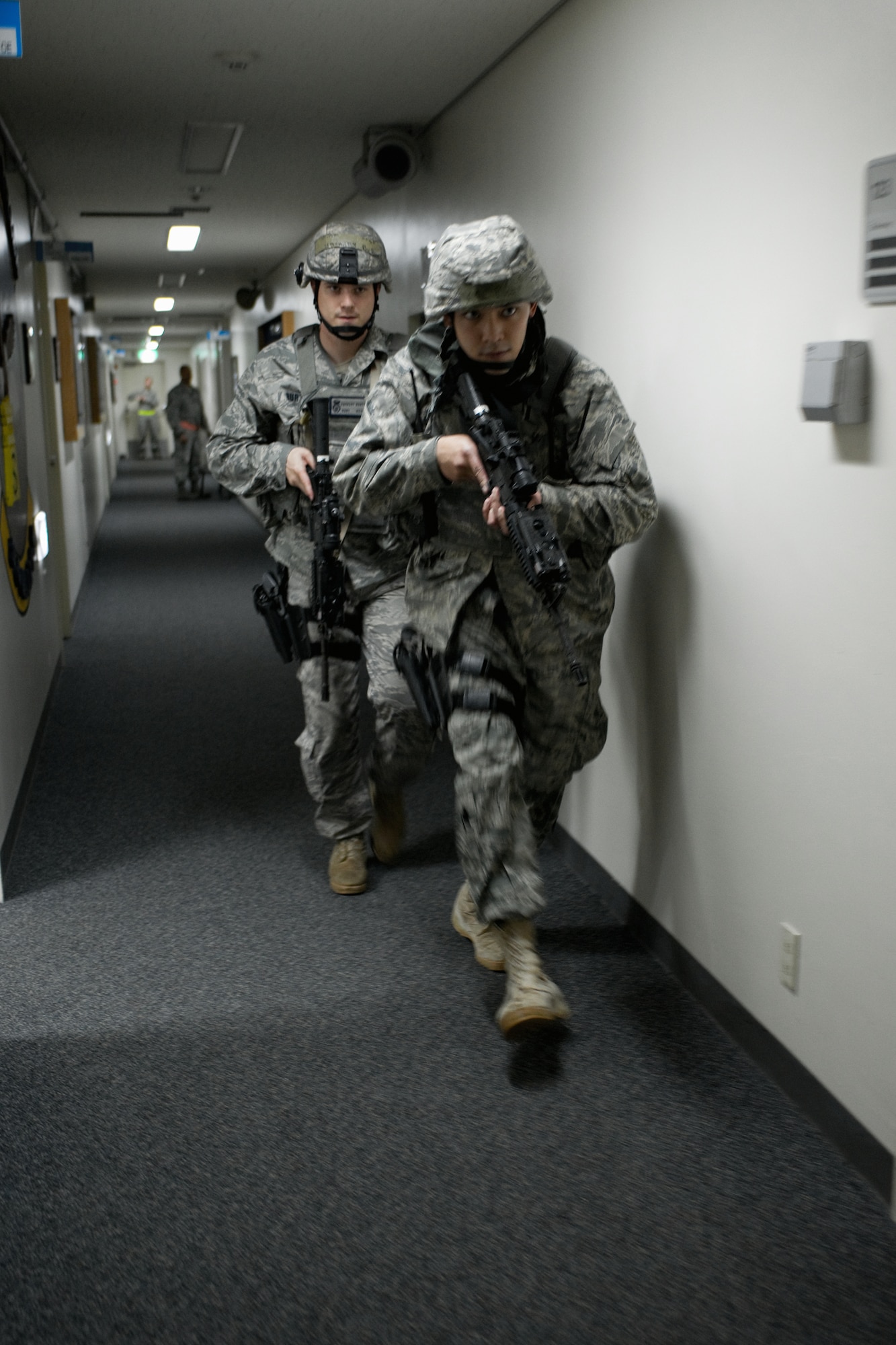 YOKOTA AIR BASE, Japan -- Airman 1st Class Limuel Beltran (front) and Staff Sgt. Zachary Burtt (back), both from the 374th Security Forces Squadron, survey a robbery site here May 24 during an operational readiness exercise. Yokota is conducting an exercise through May 27 to maintain operational readiness. (U.S. Air Force photo/Osakabe Yasuo)