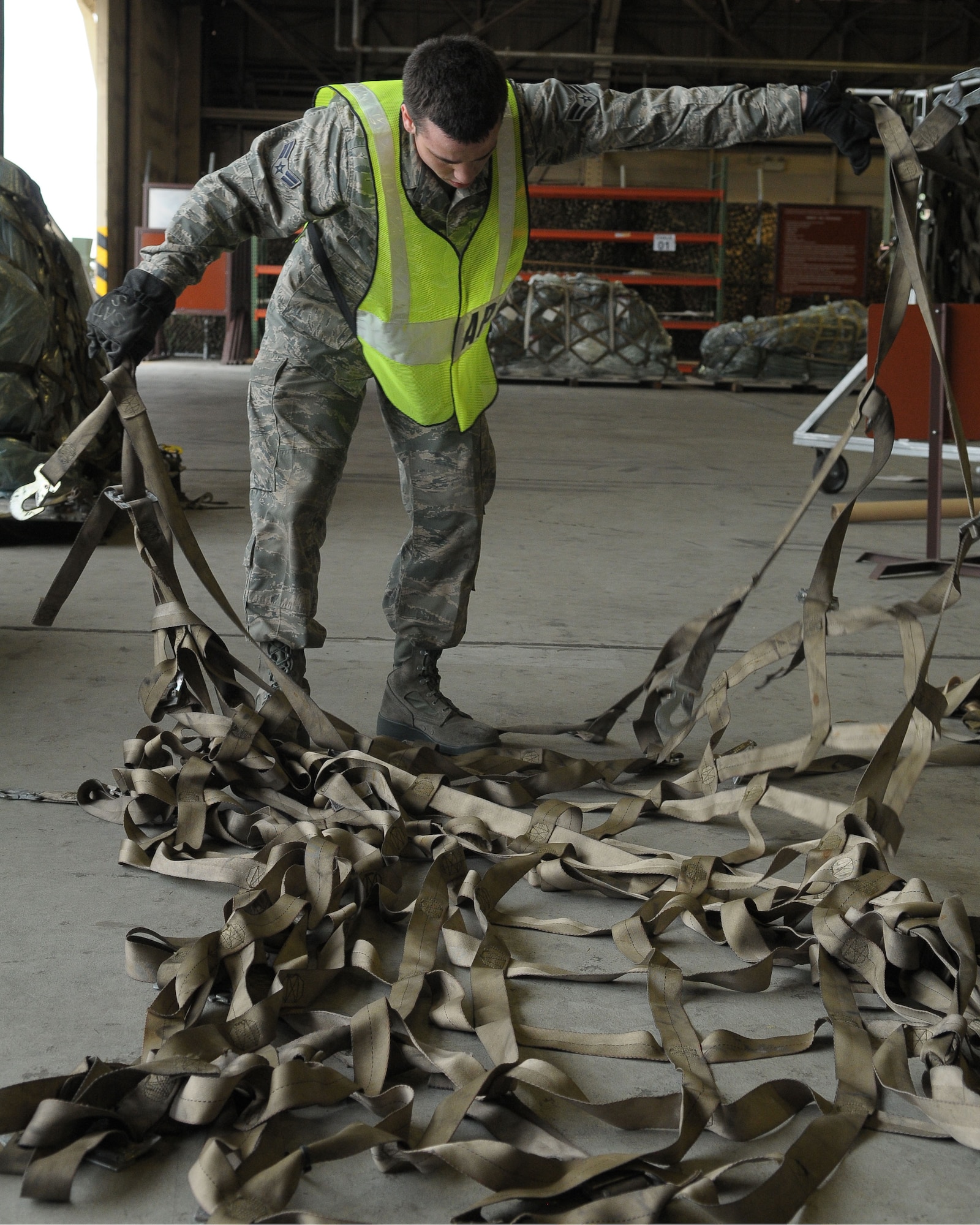 YOKOTA AIR BASE, Japan -- Airman 1st Class Benjamin Benoit, 374th Medical Operations Squadron medical administrator, untangles a cargo net used to secure cargo on pallets May 24 during an operational readiness exercise.Yokota is conducting an exercise through May 27 to maintain operational readiness. (U.S. Air Force photo/Airman 1st Class Sean Martin)