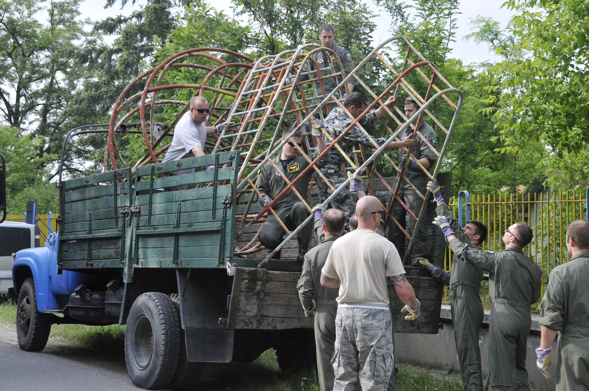 GRAF IGNATIEVO AIR FORCE BASE, Bulgaria - Members of the 48th Fighter Wing and a Bulgarian air force airman work together to load abandoned playground equipment onto a truck so it can be moved from here to nearby village Graf Ignatievo on May 21, 2010. U.S. Airmen donated $1,600 and volunteered almost 1,000 man hours to build a park in the village. (Photo by Tech. Sgt. Chris Stagner)
