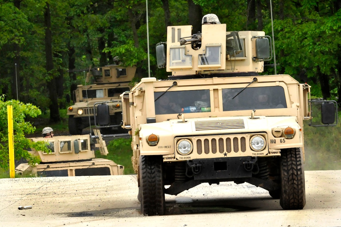 U.S. Army Calvary Scouts in up-armored HMMWV gun-trucks conduct a field ...