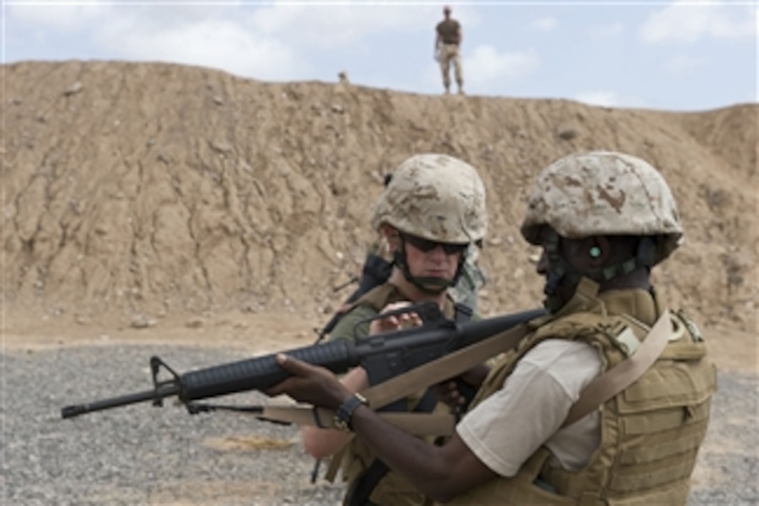 U.S. Marine Corps Cpl. Robert Wood, assigned to the armory of Combined Joint Task Force-Horn of Africa, instructs Ethiopian Lt. Col. Sultan Ebu, a coalition officer for strategic communications at the Combined Joint Task Force, on the proper procedures for firing an M-16 rifle before a U.S. Marine Corps Enhanced Marksmanship range exercise at the Djibouti City Police Department gun range on May 12, 2010.  Nearly 20 military members deployed to Camp Lemonnier, Djibouti, participated in the exercise, which focuses on advanced tactical weapons training.  