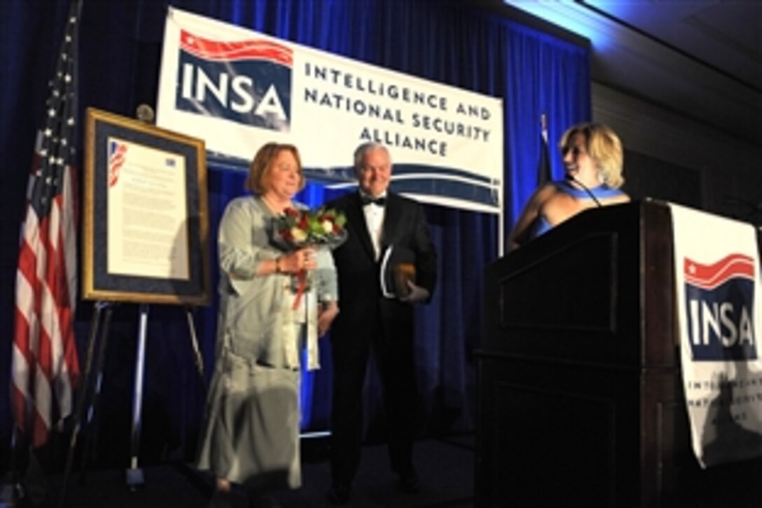 Ellen McCarthy, president of the Intelligence and National Security Alliance, presents Becky Gates with flowers for her support of Secretary of Defense Robert M. Gates' long career of public service, and her own public service during the 26th annual William Oliver Baker Award Dinner in McLean, Va., May 21, 2010. 
