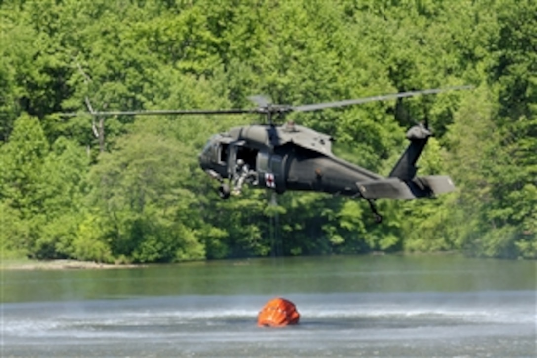 A UH-60 Black Hawk helicopter fills a suspended water bucket in Marquette Lake on Fort Indiantown Gap, Pa., May 20, 2010. The Black Hawk crew is assigned to Detachment 1, Company C, 1/169th Air Ambulance of the Pennsylvania Army National Guard, and is training on the water drops in preparation for an upcoming deployment to Kosovo, where there is a possibility of conducting water drops for humanitarian efforts such as extinguishing brush fires.