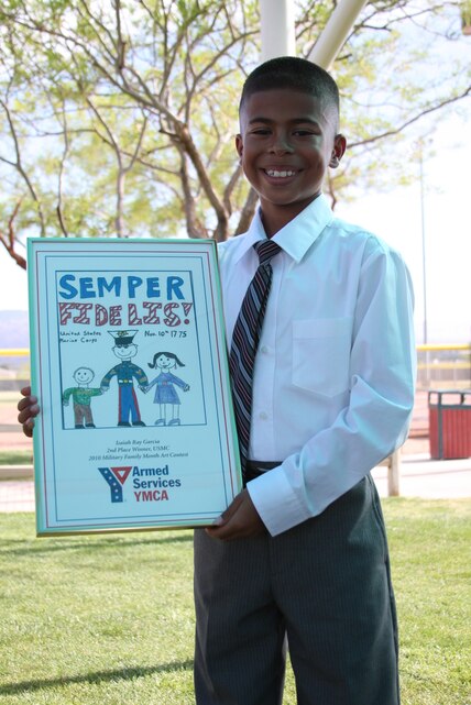 Isaiah Garcia, proudly shows off his award winning picture at Felix Field May 25, which won him second place in the Armed Services YMCA art contest. Isaiah participated in a nationwide competition, and his original picture is now displayed in Washington, D.C.