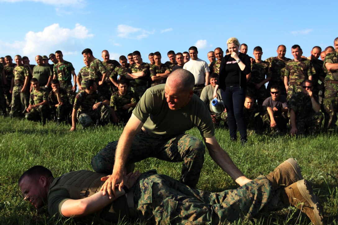 Cpl. Mitchell Staats, an assaultman with scout platoon, Headquarters and Service Company, 1st Tank Battalion, subdues an opponent after being sprayed with Oleoresin Capsicum, more commonly known as pepper spray, during a nonlethal weapons exercise at Babadag Training Area, Romania, May 25.