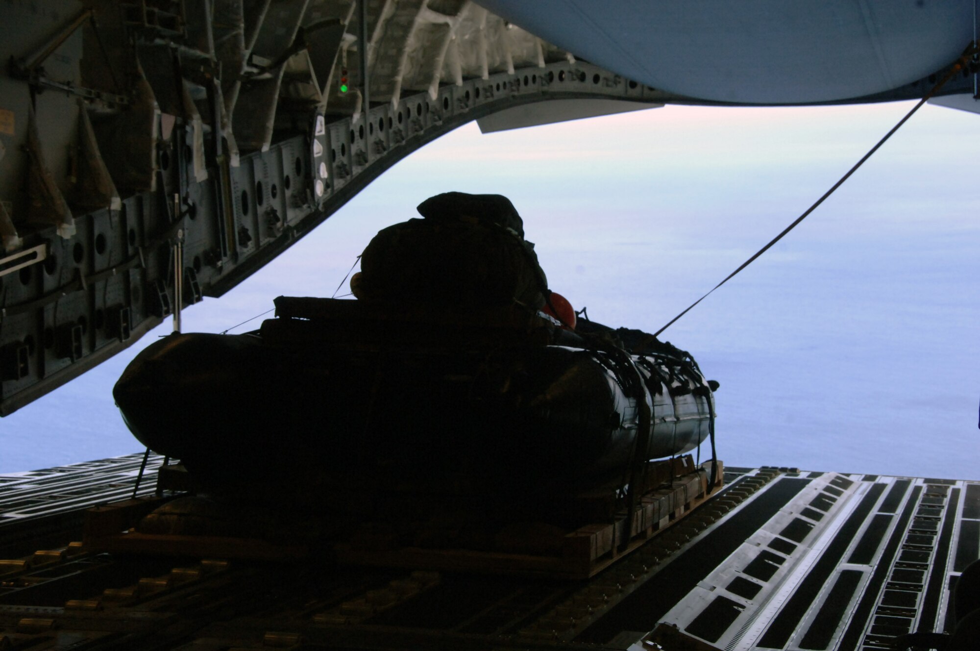 A pallet containing an inflated raft flies out of a C-17 during an orientation flight May 24 at Joint Base Pearl Harbor Hickam, Hi. The orientation flight was an opportunity for Air Force, Navy, and Air National Guard leaders to get a better understanding of each other's needs and capabilities. (U.S. Air Force photo by Senior Airman Nathan Allen)