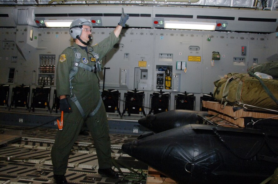 Master Sgt. Brian Chewning, 15th Operations Group Standards and Evaluation superintendent, prepares to cut free a pallet during an orientation flight May 24 at Joint Base Pearl Harbor Hickam, Hi. The orientation flight was an opportunity for Air Force, Navy, and Air National Guard leaders to get a better understanding of each other's needs and capabilities. (U.S. Air Force photo by Senior Airman Nathan Allen)