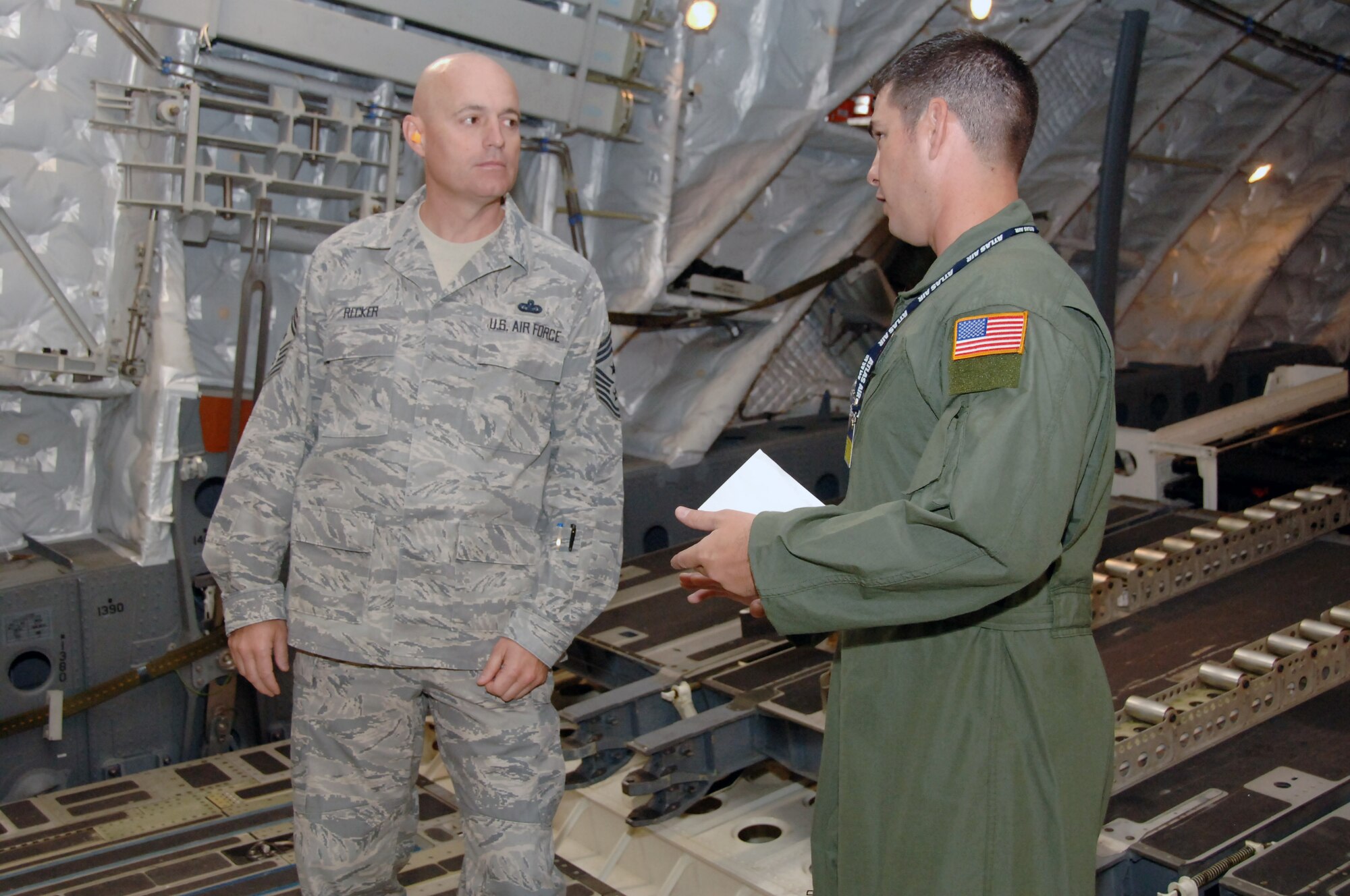 Chief Master Sgt. Craig Recker, 15th Air Wing command chief, talks with Master Sgt. Chuck Baker, 535th Airlift Squadron loadmaster superintendent, during an orientation flight May 24 at Joint Base Pearl Harbor Hickam, Hi. The orientation flight was an opportunity for Air Force, Navy, and Air National Guard leaders to get a better understanding of each other's needs and capabilities. (U.S. Air Force photo by Senior Airman Nathan Allen)
