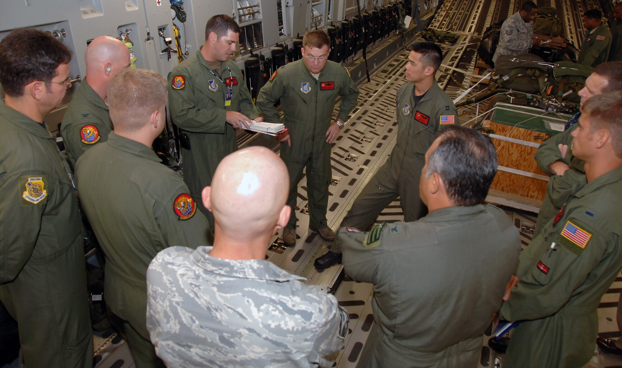 Aircrew members and passengers of the orientation flight talk before taking off May 24 at Joint Base Pearl Harbor Hickam, Hi. The orientation flight was an opportunity for Air Force, Navy, and Air National Guard leaders to get a better understanding of each other's needs and capabilities. (U.S. Air Force photo by Senior Airman Nathan Allen)