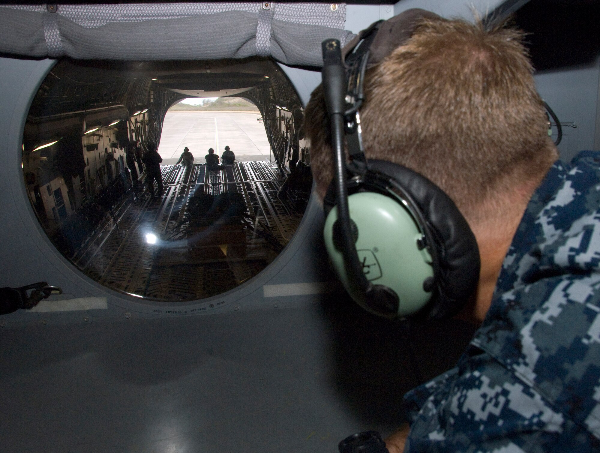 Capt. Randy Moore, Fleet Industrial Supply Center commanding officer, peers through a window during an orientation flight May 24 at Joint Base Pearl Harbor Hickam, Hi. The orientation flight was an opportunity for Air Force, Navy, and Air National Guard leaders to get a better understanding of each other's needs and capabilities. (U.S. Air Force photo by Senior Airman Nathan Allen)