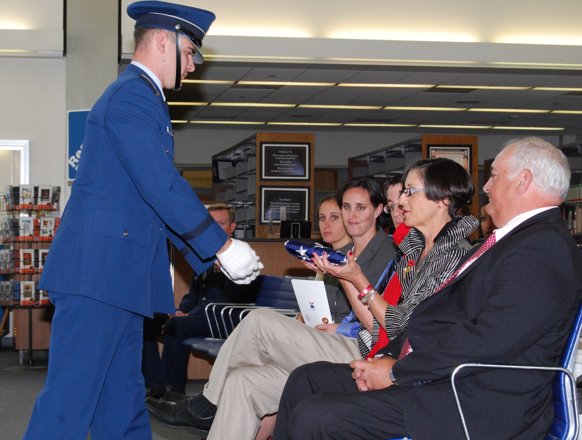Cadet 2nd Class Grant Hadley presents Susie Schulte with an American flag during the inaugural Lieutenant Roslyn Schulte Cadet Character and Leadership Award ceremony in the Air Force Academy's McDermott Library May 25, 2010. The flag was flown over the Academy May 20, 2010, on the one-year anniversary of 1st Lt. Roslyn Schulte's death. Also pictured are, from right: Lieutenant Schulte's father, Bob Schulte, and her cousins, Neil, Sarah and Jessica Littman. (U.S. Air Force photo/Staff Sgt. Don Branum)