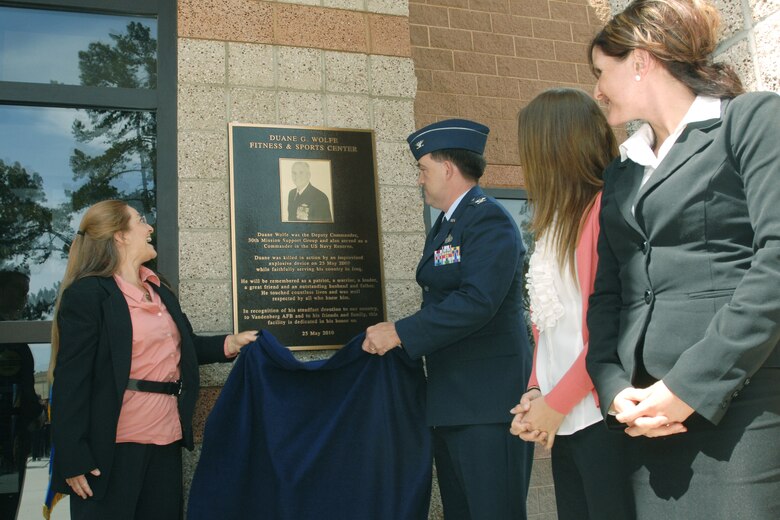 VANDENBERG AIR FORCE BASE, Calif. – Cindi Wolfe, wife of Navy Cmdr. Duane Wolfe, and Col. Richard Wright, the 30th Mission Support Group commander, unveil a plaque honoring Commander Wolfe during the fitness center dedication ceremony here Tuesday, May 25, 2010. Commander Wolfe was the deputy commander of the 30th Mission Support Group and also served as a commander in the U.S. Navy Reserve. (U.S. Air Force photo/Senior Airman Christopher Hubenthal)