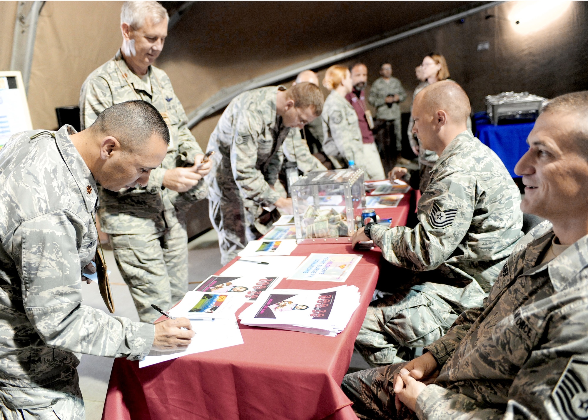 Airmen fill out pledge forms for the "300 Lives in 30 Days" fundraiser April 21, 2010, at the Transit Center at Manas, Kyrgyzstan. Airmen raised $50,000 for the children's heart surgery fund -- enough to fund almost 90 surgeries for children. (U.S. Air Force photo/Senior Airman Nichelle Anderson)