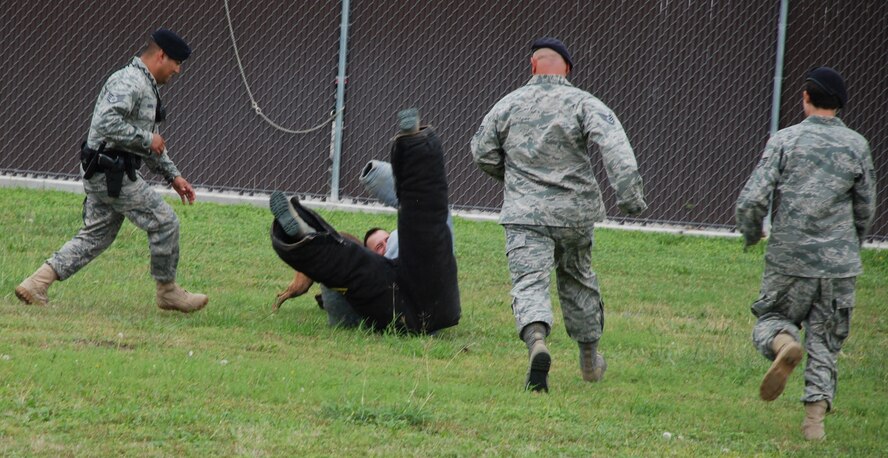 LAUGHLIN AIR FORCE BASE, Texas – Col. Andrew Cernicky, 47th Mission Support Group commander, participates in a military working dog demonstration with Xavier, one of Laughlin’s military working dogs, as Staff Sgt. Britney Simpson, Staff Sgt. Bryan Garcia and Staff Sgt. Derrick Bowen, all of 47th Security Forces Squadron, make sure the demonstration doesn’t get out of hand. (U.S. Air Force photo by Airman 1st Class Blake Mize) 