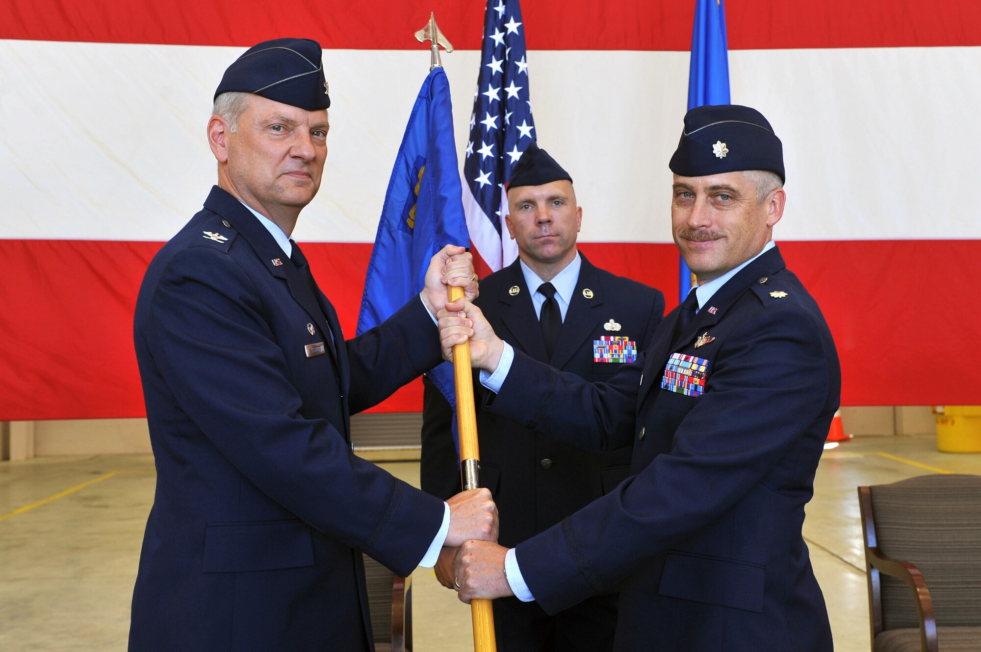 Col. David Kasberg, 19th Operations Group commander, passes the 53rd Airlift Squadron guidon to Lt. Col. Ken Kopp, 53rd AS commander, at a change-of-command ceremony May 21. Colonel Kopp assumed command after Lt. Col. Sean Bordenave relinquished command. (U.S. Air Force photo by Senior Airman Chris Willis)