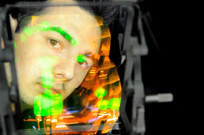 U.S. Air Force Senior Airman Keiron Legg looks through the combined glass which is lit up by the C-17 Heads-Up Display Unit May 25, 2010, at Joint Base Charleston, S.C. The Avionics Shop recently won the Chief of Staff Team Excellence Award for 2009 from Air Force Reserve Command.  Innovations designed by Charleston?s Avionics Shop in the repair process of Heads-Up Display Units were instrumental in winning this award and competing at the Air Force level. Airman Legg is a test station and components journeyman with the 437th Maintenance Squadron. (U.S. Air Force photo/James M. Bowman) 