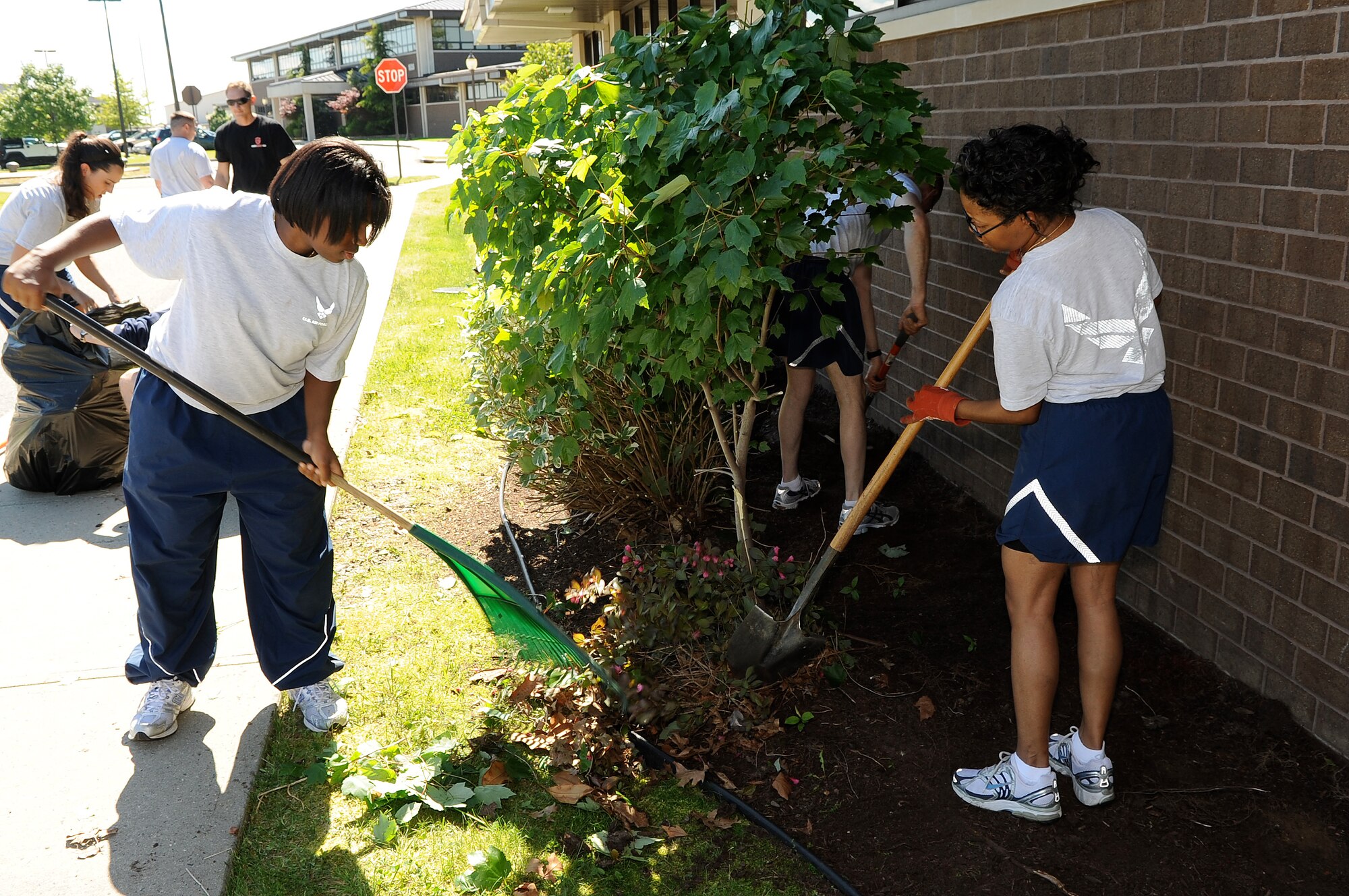 Staff Sgt. Sheana Rodriguez and Master Sgt. Andrea Boswell, aviation resource managers, clear weeds away while other members of the 32nd Aerial Refueling Squadron bag trash, trim hedges and rake the flower beds surrounding the 32nd ARS building. They joined the rest of the Joint Base McGuire-Dix-Lakehurst community in celebrating Base Pride Day May 20. (U.S. Air Force photo/Wayne Russell)
