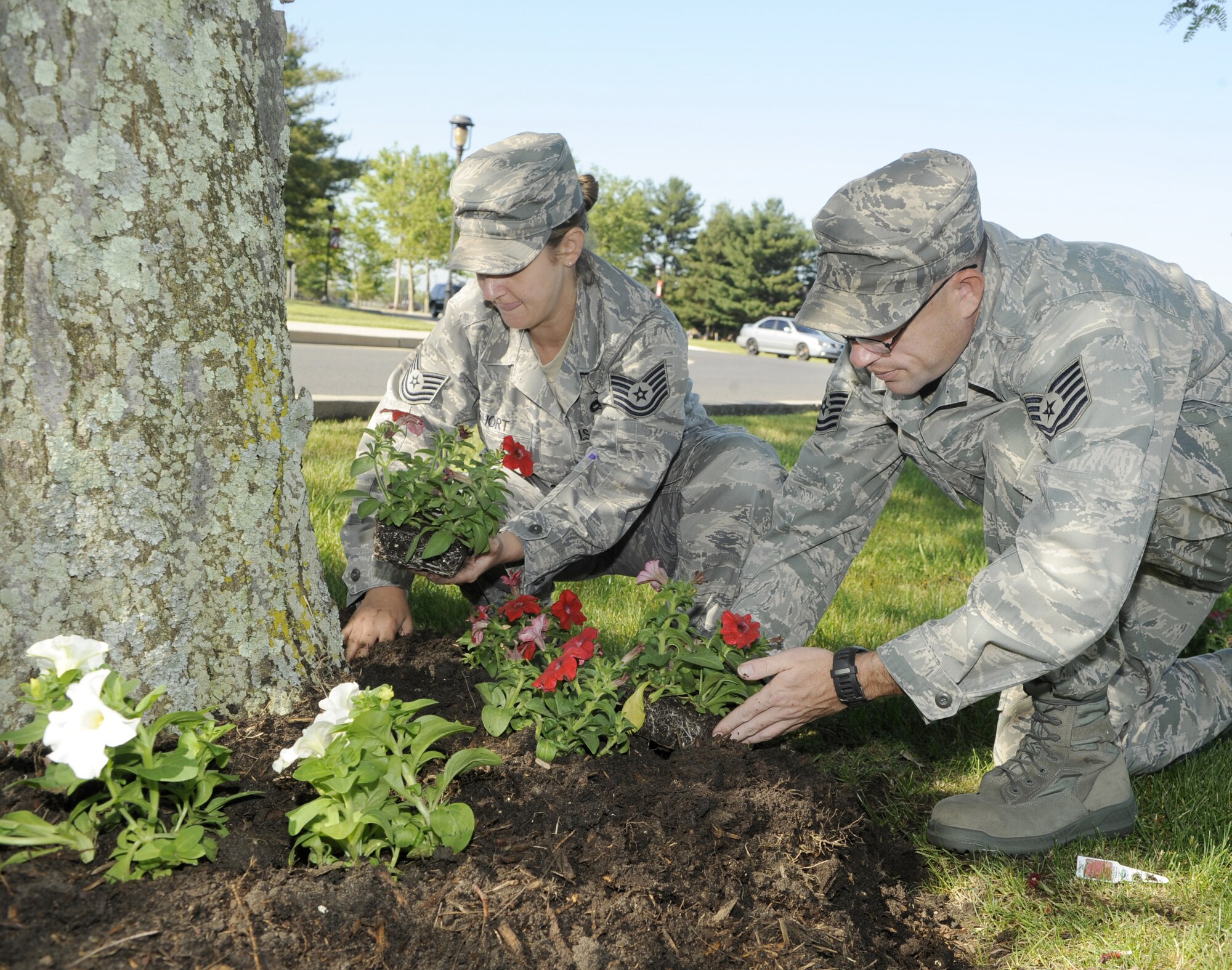 Tech. Sgt. Lori Short and Tech. Sgt. Christopher Furr, both from the 87th Communications Squadron, spend the day planting flowers in honor of Base Pride Day May 20. Servicemembers were able to pick up flowers and other gardening supplies from the base Self Help Center here throughout the day.  (U.S. Air Force photo/Carlos Cintron)
