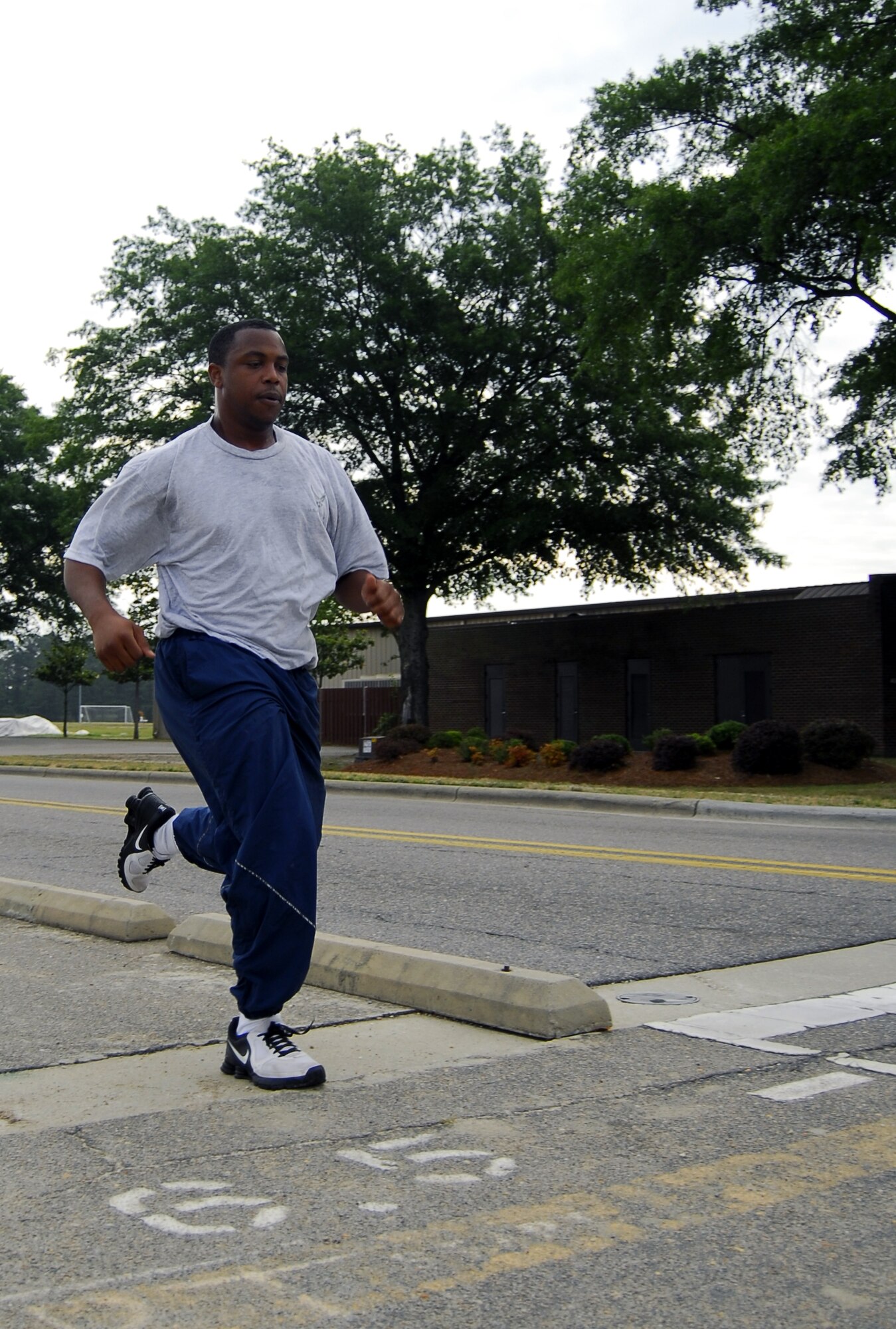 Airman 1st Class Tommy Pemberton, 43rd Force Support Squadron, crosses the finish line for the 1.5-mile run on the perimeter of the Pope flightline during his annual PT test, May 20. Airmen assigned to FSS are required to participate in group training at least once a week.  (U.S. Air Force Photo/2nd Lt. Cammie Quinn)