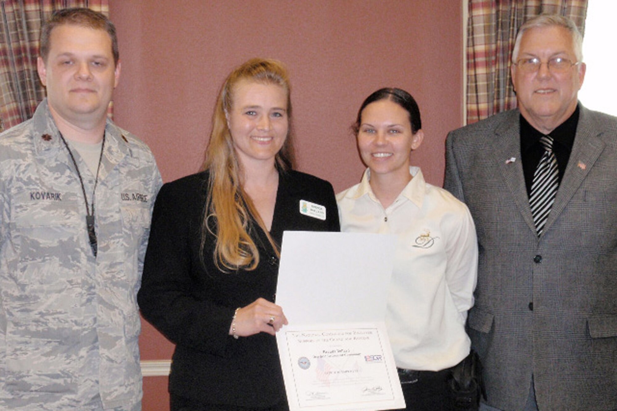 DES MOINES, IA - Brenda Ballard of Deerfield Retirement Community (second from left) is the recipient of a Patriotic Employer award from Iowa Committee of Employer Support of the Guard and Reserve. She was nominated by Alicia Bollie (second from right), a Deerfield employee and a Staff Sergeant with the Iowa Air National Guard, for Deerfield?s support of employees who are members of the military.  At left is Major Kyle Kovarik, 132nd Fighter Wing. At right is Ted Hall, a volunteer with Iowa ESGR.(Civilian photographer)(released)         