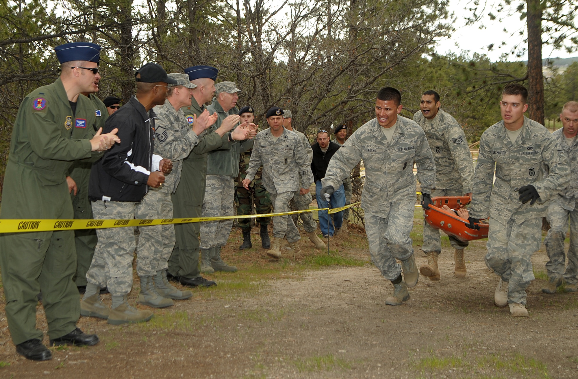 Airman Ricardo Reyna and Airman 1st Class Christopher Uremovich, 460th Security Forces Squadron, and Staff Sgts. Mario Hernandez and Randall Fischer, 137th Space Warning Squadron, carry a training dummy to the finish as fellow Team Buckley members cheer them on May 19. (U.S. Air Force photo by Duncan Wood)