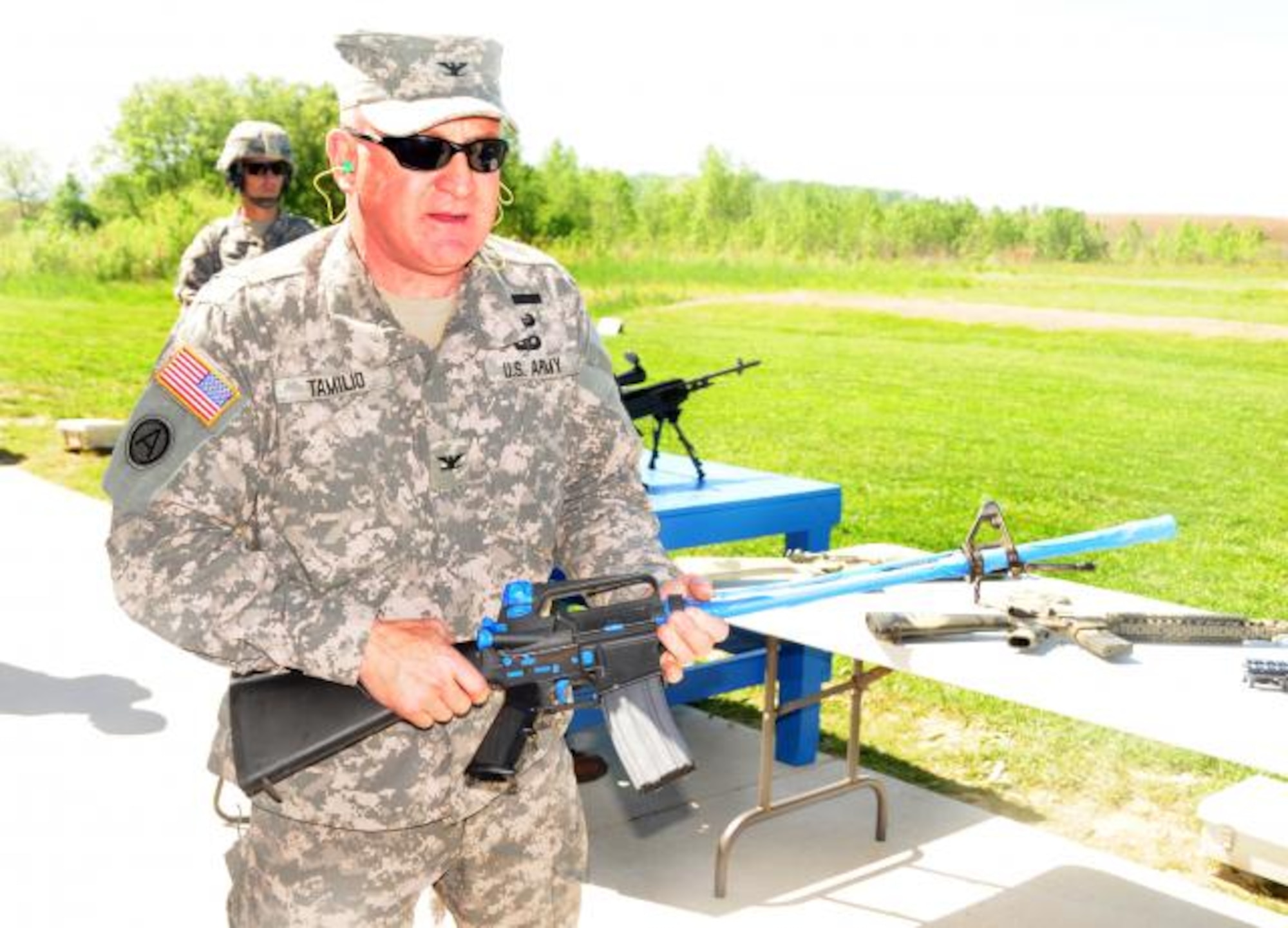 Col. Douglas A. Tamilio, project manager for Soldier Weapons, Program Executive Office Soldier, holds a M16 rifle that has been taped up in preparation for applying spray paint camouflage. (U.S. Army photo/C. Todd Lopez)