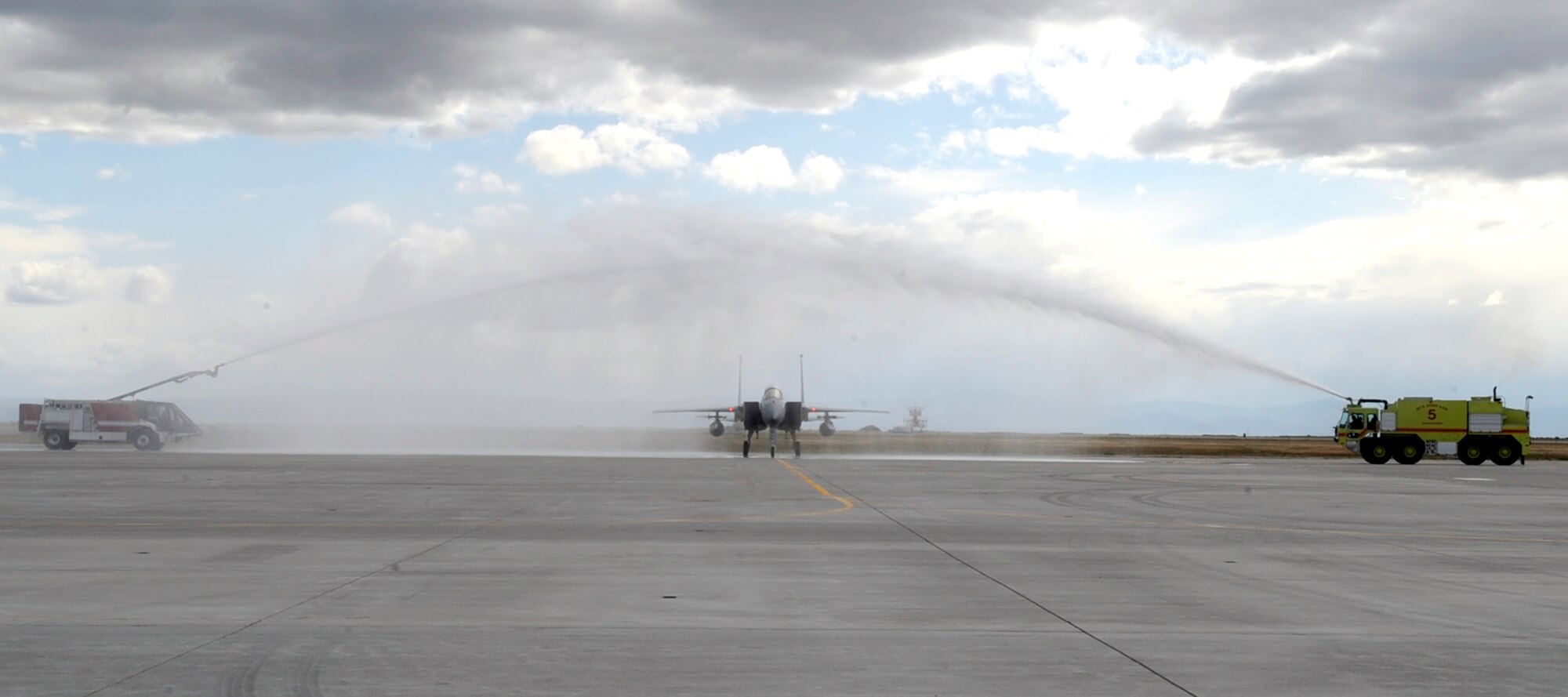 MOUNTAIN HOME AIR FORCE BASE, Idaho -- Passing under the water cannons, Col. John Bird, former 366th Fighter Wing commander, ends his final F-15C Strike Eagle flight at Mountain Home May 21. Colonel Bird has been selected to serve on the Joint Staff in Washington D.C. as the Chief of the Force Application Division at the Pentagon. (U.S. Air Force photo by Airman 1st Class Angelina Drake)