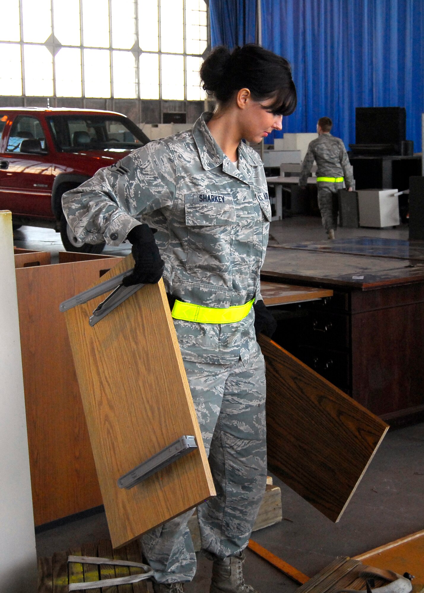 Airman 1st Class Erin Sharkey, 6S event volunteer and member of the 43rd Logistics Readiness Squadron, carries shelves over to a flat bed truck for removal from Hangar 4 on May 20. The 6S event helped organizations dispose of more than 17,000 pounds of computer equipment and 60,000 pounds of additional equipment. (U.S. Air Force photo/Senior Airman Kris Levasseur)