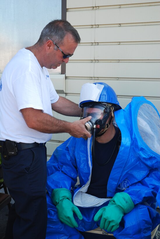 A fire fighter gets assistant with his protective HAZMAT gear during a training course at Westover.  Fire fighters from around Massachusetts converged on the base for the Massachusetts Fire Fighter Academy's 160-hour Hazardous Materials Technician Course that was hosted here in May.