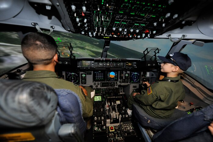 U.S. Air Force Capt. Kyle Clinton and A.J. Risor fly a C-17 simulator on Joint Base Charleston, S.C., May 21, 2010. Captain Clinton is an instructor pilot with the 15th Airlift Squadron and A.J. is the "Pilot for a Day." The Pilot for a Day program is an Air Force-wide program which helps seriously ill children to become honorary pilots for a day. The base works in conjunction with the South Carolina Make-a-Wish Foundation and the Medical University of South Carolina to identify the children who participate in the program. (U.S. Air Force photo/James M. Bowman)