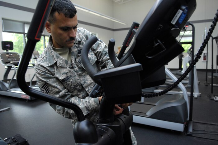 Tech. Sgt. Alexander Oritz checks the wires on a remote for the cardio theater on an elliptical at the Fitness and Sports Center on Joint Base Charleston, S.C., May 24, 2010. Recent complaints revealed the screen was not working properly. Sergeant Oritz provides routine maintenance to the machines on a daily basis based on complaints or problems that he spots himself. Sergeant Oritz is a fitness specialist from the 482nd Force Support Squadron at Homestead Air Reserve Base, Fla. (U.S. Air Force Photo/Airman 1st Class Lauren Main)