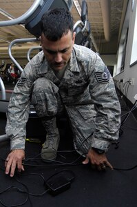 Tech. Sgt. Alexander Oritz aligns and organizes the wires from a treadmill at the Fitness and Sports Center on Joint Base Charleston, S.C., May 24, 2010. By organizing the wires, Sergeant Oritz helps eliminate tripping hazards and ensures that the gym is a safer place. Sergeant Oritz is a fitness specialist from the 482nd Force Support Squadron at Homestead Air Reserve Base, Fla. (U.S. Air Force Photo/Airman 1st Class Lauren Main)