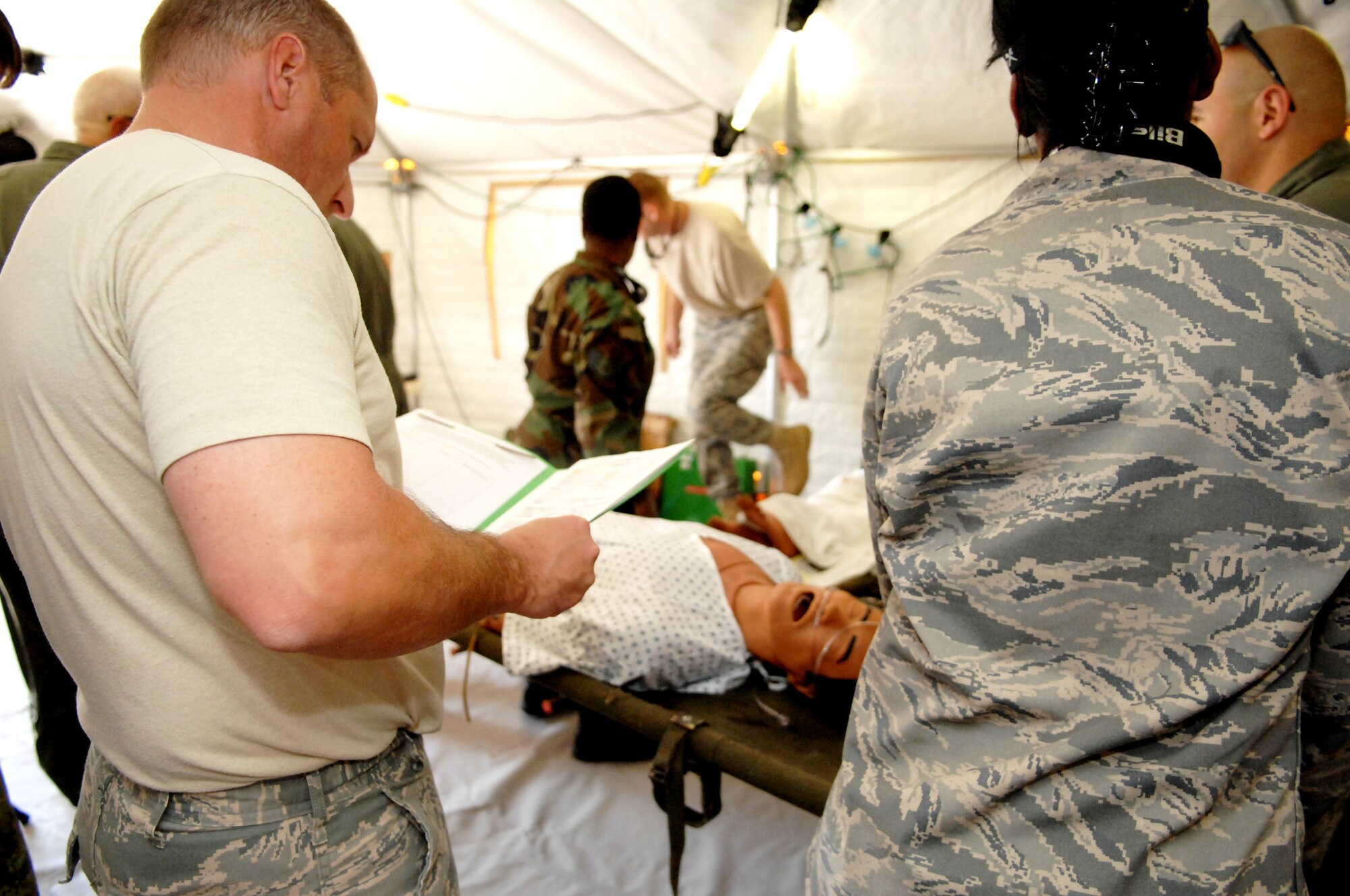 NEW ORLEANS -- Capt. Tom Lionberger, patient movement clinical coordinator from Transportation Command at Scott AFB, Ill., reviews a patient’s chart while he is carried into the Disaster Aeromedical Staging Facility during an evacuation exercise at the New Orleans Lakefront Airport May 18. The exercise was controlled by the Louisiana Department of Health and Hospitals with the help of multiple military counterparts including Air Mobility Command and United States Transportation Command members from Scott AFB. (U.S. Air Force photo by Senior Airman Samantha S. Crane)