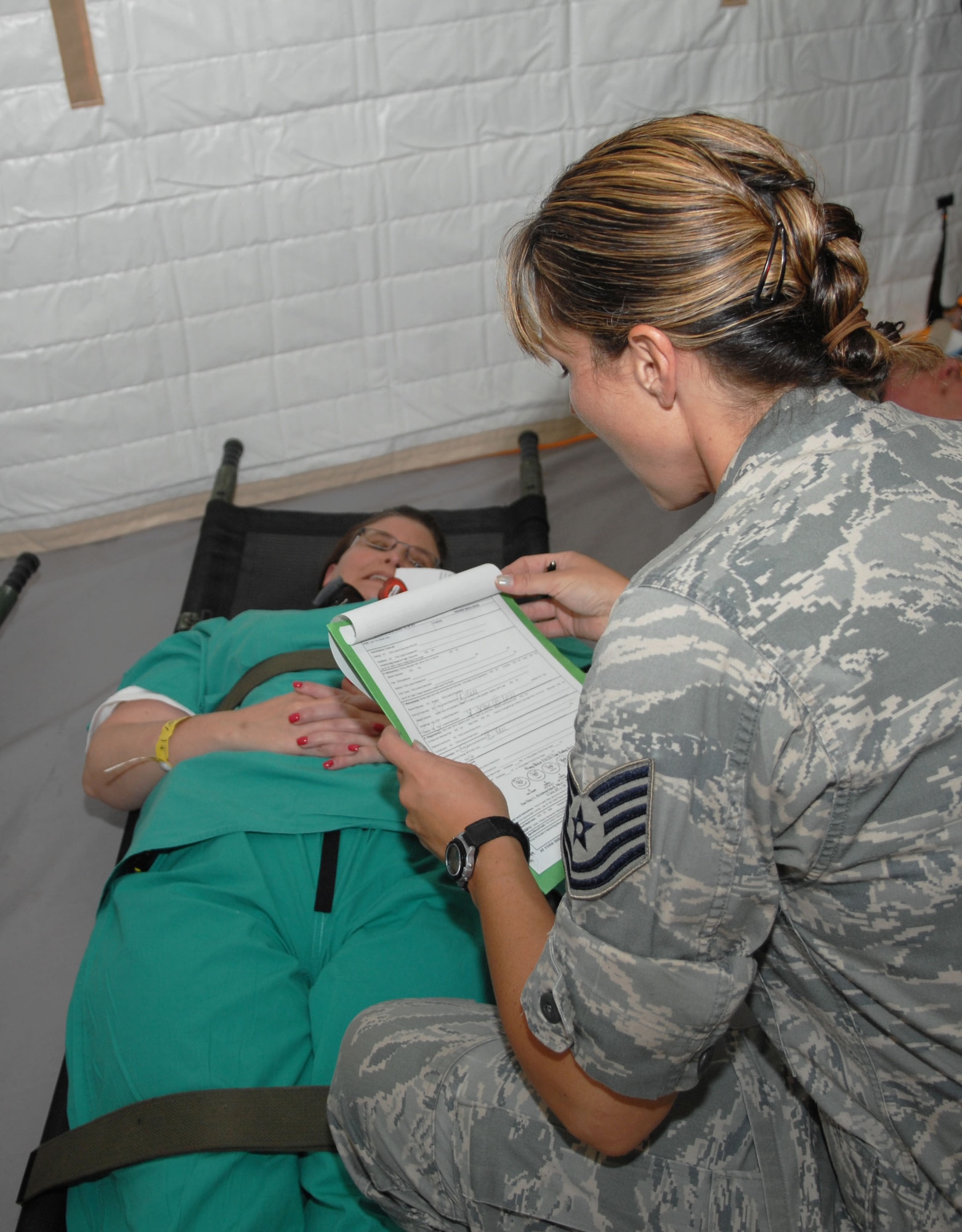 NEW ORLEANS -- Tech. Sgt. Adele Filek, a medical technician from Charleston AFB, S.C., reviews a simulated patient’s chart during an evacuation exercise at the New Orleans Lakefront Airport May 18. The exercise was controlled by the Louisiana Department of Health and Hospitals with the help of multiple military counterparts including Air Mobility Command and U.S. Transportation Command members from Scott AFB. (U.S. Air Force photo by Senior Airman Samantha S. Crane)