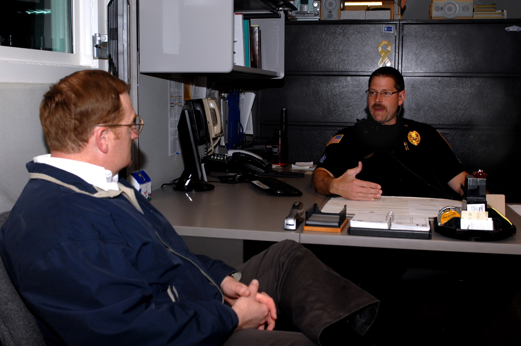 MINOT, N.D. -- Sgt. Paul C. Burns, Minot Police Department shift commander, briefs Col. Douglas A. Cox, 5th Bomb Wing commander at the police department here May 21. Colonel Cox was downtown to participate in the Minot AFB & Minot PD Supervisor 'Ride-Along' Program. The new program is designed to enhance the partnership between base officials and local law enforcement and help increase the understanding of the areas of concern related to DUI incidents among the base population.  (U.S. Air Force photo by Airman 1st Class Aaron-Forrest Wainwright)