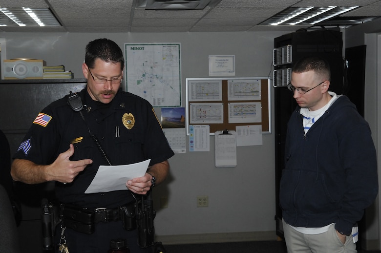 MINOT, N.D. -- Sgt. Paul C. Burns, Minot Police Department shift commander, briefs Maj. Kyle Smet, 5th Bomb Wing executive officer, at the police department here May 21. Major Smet was downtown to participate in the Minot AFB & Minot PD Supervisor 'Ride-Along' Program. The new program is designed to enhance the partnership between base officials and local law enforcement and help increase the understanding of the areas of concern related to DUI incidents among the base population. (U.S. Air Force photo by Staff Sgt. Miguel Lara III)
