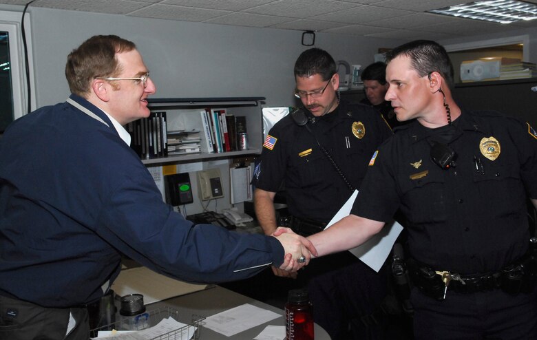 MINOT, N.D. -- Col. Douglas A. Cox, 5th Bomb Wing commander, is greeted by Officer Steve Schoenrock, Minot Police Department senior patrolman at the police department here May 21. Colonel Cox was downtown to participate in the Minot AFB & Minot PD Supervisor 'Ride-Along' Program. The new program is designed to enhance the partnership between base officials and local law enforcement and help increase the understanding of the areas of concern related to DUI incidents among the base population.  (U.S. Air Force photo by Staff Sgt. Miguel Lara III)