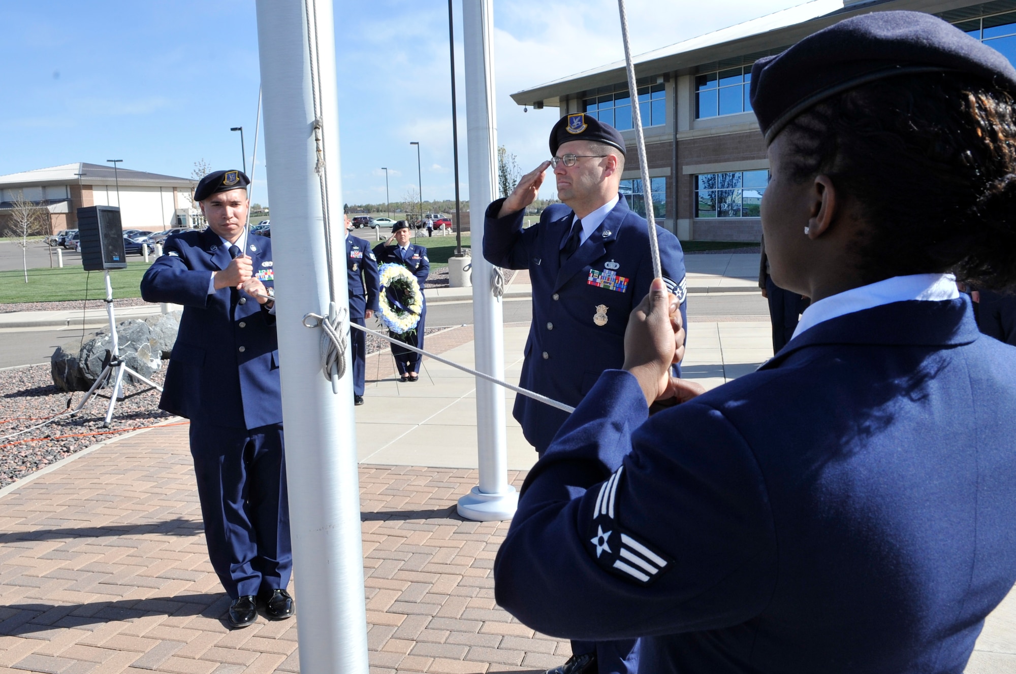 BUCKLEY AIR FORCE BASE, Colo. -- Senior Airman Steven Pillman, Staff Sgt. Thomas Gehres and Senior Airman Lauren Myrick, all 460th Security Forces Squadron, lower the American flag during a National Police Week retreat ceremony May 10. (U.S. Air Force photo by Airman 1st Class Paul Labbe)