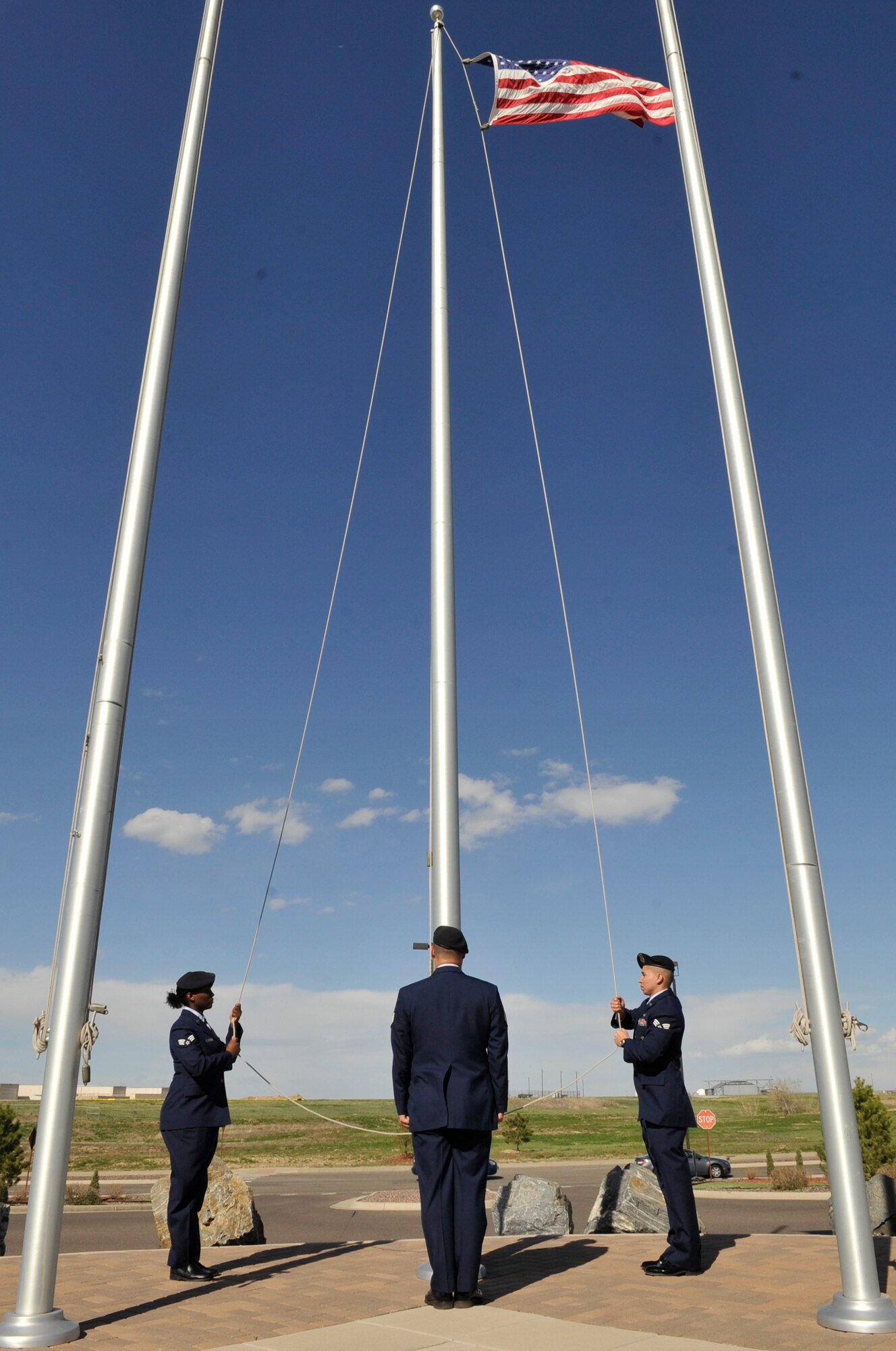 BUCKLEY AIR FORCE BASE, Colo. -- Senior Airman Lauren Myrick, Staff Sgt.Thomas Gehres and Senior Airman Steven Pillman, all 460th Security Forces Squadron, lower the American flag during a National Police Week retreat ceremony May 10. (U.S. Air Force photo by Airman 1st Class Paul Labbe)
