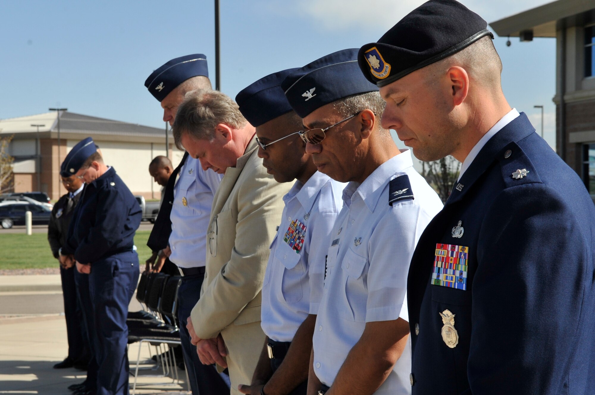 BUCKLEY AIR FORCE BASE, Colo. -- From front to back, Lt.Col. Matthew Boschert, 460th Security Forces Squadron commander, Col. Vincent Jefferson, 460th Mission Support Group commander, Chief Master Sgt. Robert Ellis, 460th SW command chief, Douglas Carroll, 460th SW director of staff and Col. Trent Pickering, 460th Space Wing vice commander, bow their heads during an invocation at the National Police Week retreat ceremony May 10. (U.S. photo by Airman 1st Class Paul Labbe)
