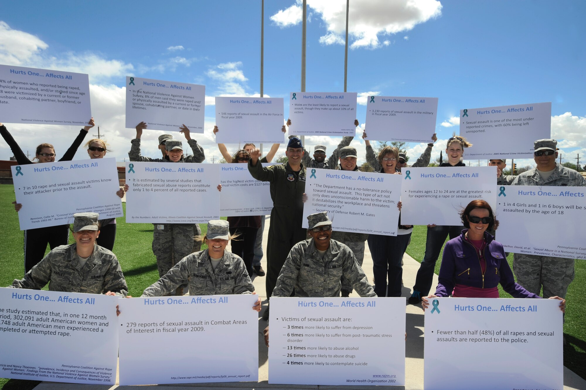 HOLLOMAN AIR FORCE BASE, N.M. -- Team Holloman members hold up signs for a group photo during the Sexual Assault and Awareness walk April, 23, 2010. Col. Jeff Harrigian, 49th Fighter Wing commander, showed his support along with Airmen and their families by participating in the walk to prevent sexual assults. (U.S. Air Force photo by Airman 1st Class Veronica Stamps / Released)
