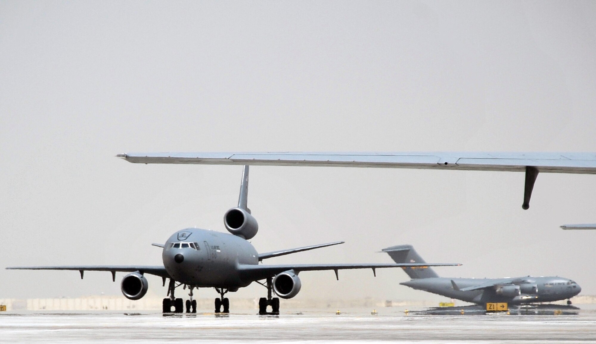 An aircrew from the 908th Expeditionary Air Refueling Squadron steers a KC-10 Extender down the taxiway of the flightline for the 380th Air Expeditionary Wing while a C-17 Globemaster III taxis behind it at a non-disclosed base in Southwest Asia on May 19, 2010. The 380th AEW supports operations Iraqi Freedom and Enduring Freedom and the Combined Joint Task Force-Horn of Africa (U.S. Air Force Photo/Master Sgt. Scott T. Sturkol/Released)
