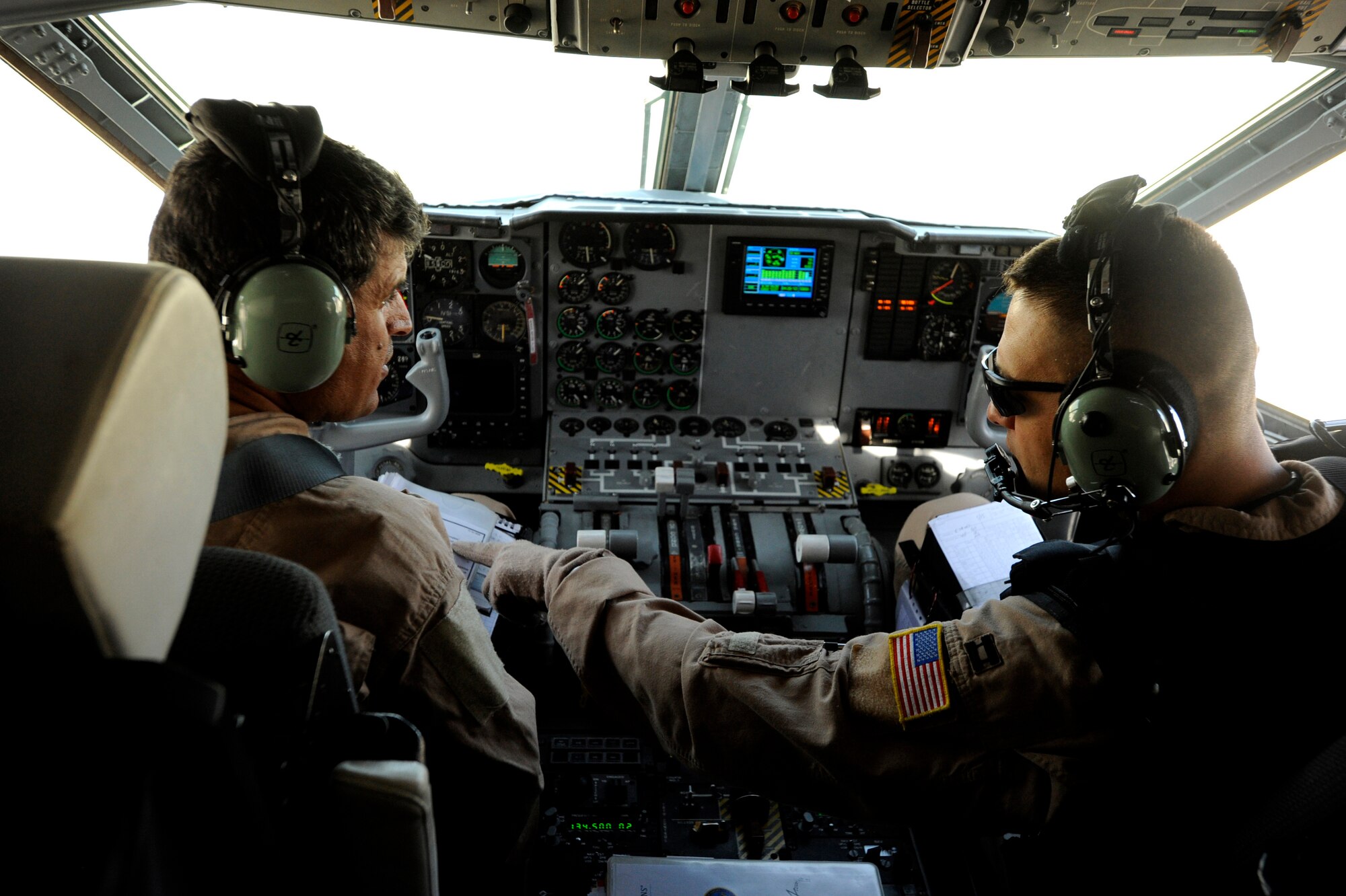 U.S. Air Force Capt. Larry Needham, right, a C-27J Spartan pilot assigned to the 538th Air Expeditionary Advisory Squadron, goes over pre-flight checklist items with Capt. Mohammad-Shah Ahmadzai, an Afghanistan National Army Air Corps C-27J pilot, prior to take-off for an operational mission May 15, 2010, at Kabul International Airport, Afghanistan. Since November 2009, Combined Air Power Transition Force Airmen have been training Afghan C-27 pilots and loadmasters to conduct strategic and tactical airlift, airdrops and presidential support.  (U.S. Air Force/ Staff Sgt. Manuel J. Martinez)  
