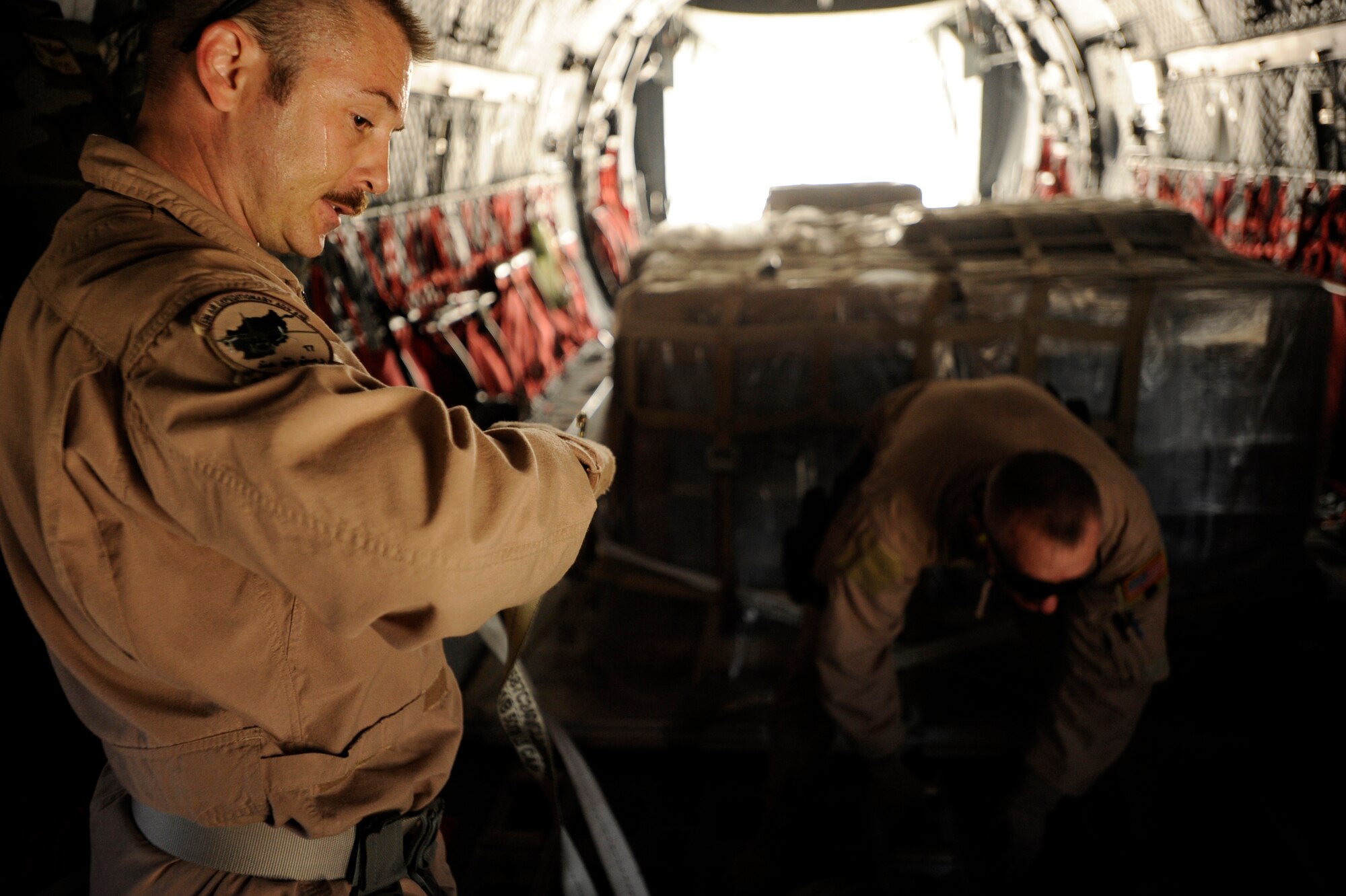 Master Sgt. Chris Beckwith and Senior Master Sgt. Mike Crews, C-27J Spartan loadmaster advisors assigned to the 538th Air Expeditionary Advisory Squadron, secure all loose cargo in a C-27 aircraft prior to take-off for a mission, May 15, 2010, at Kabul International Airport, Afghanistan.(U.S. Air Force/ Staff Sgt. Manuel J. Martinez/released)  