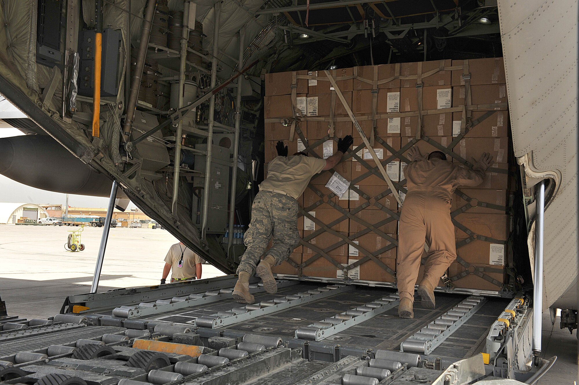 U.S. Air Force loadmaster Master Sgt. Mark Norman. right, and an aerial-port worker load a pallet filled with medical supplies, hygiene kits and water onto an C-130 Hercules destined for flood relief victims in Tajikistan May 21, 2010.  Sergeant Norman is deployed to the 774th Airlift Squadron, Bagram Airfield, Afghanistan.  (U.S. Air Force photo/Staff Sgt. Quinton Russ/released)