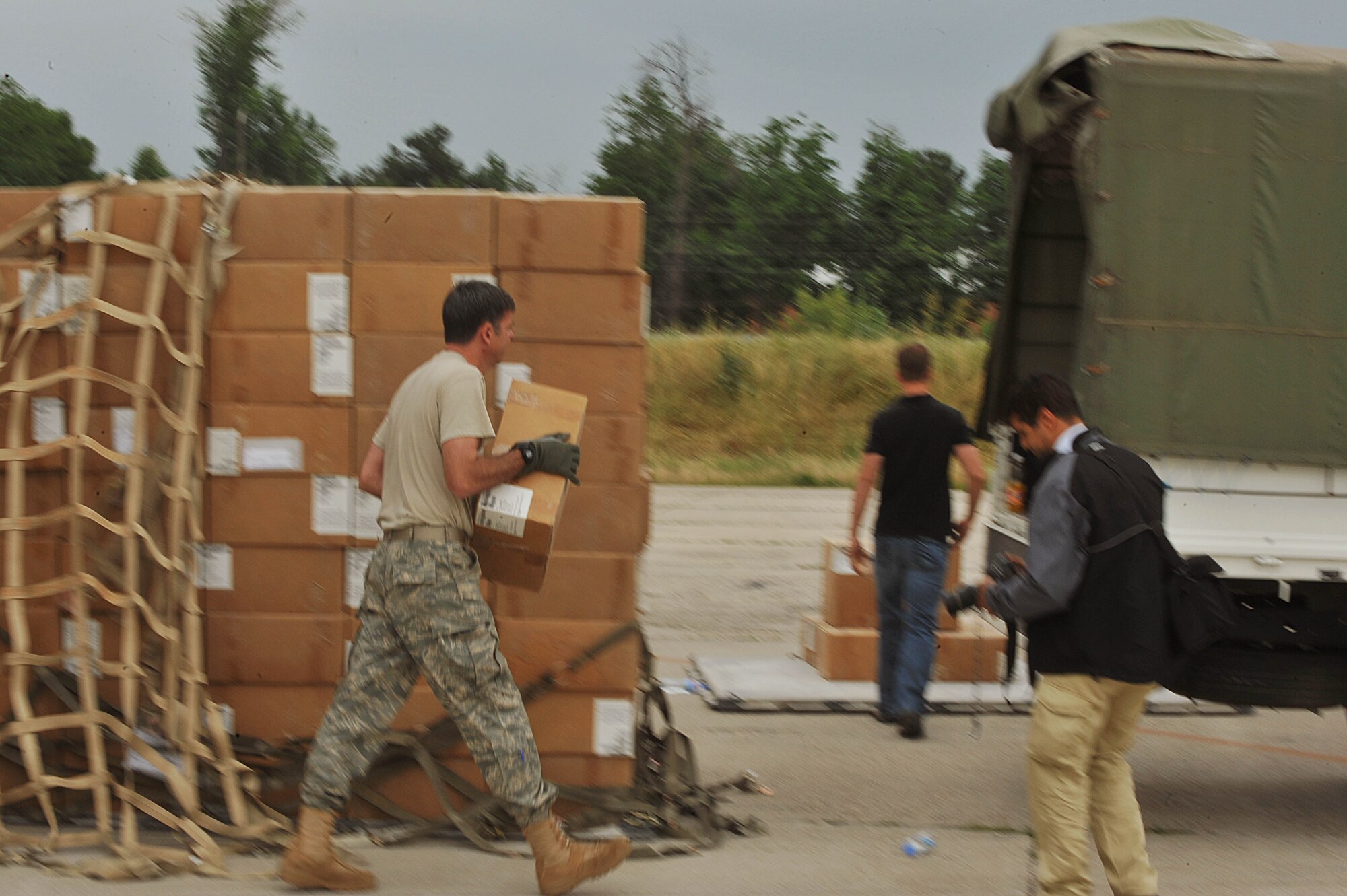 U.S. Air Force Chief Master Sgt. Jim Carson, center, unloads a pallet full of medical supplies, hygiene kits and water at Dushanbe International Airport, Tajikistan, May 21, 2010.  The humanitarian cargo is for Tajiks displaced from their homes after floods and mudslides ravaged Kulyab District earlier this month. Chief Carson is the operations coordinator for the U.S. Embassy.  (U.S. Air Force photo/Staff Sgt. Quinton Russ/released)